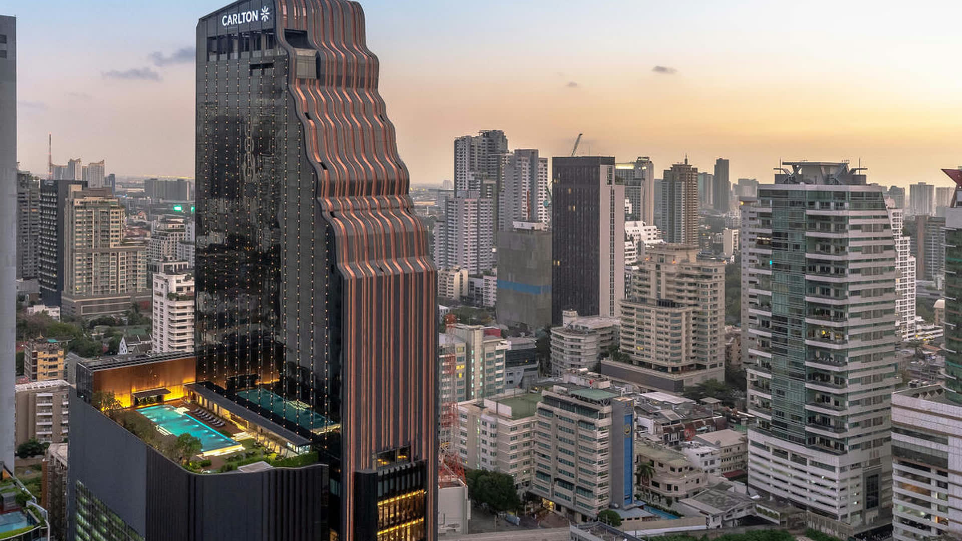 The Carlton tower over the Bangkok skyline at golden hour